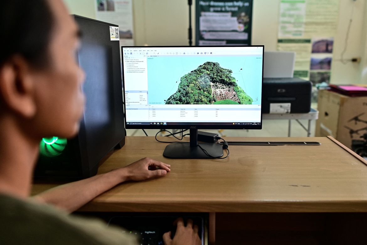 This picture taken on November 22, 2023 shows Chiang Mai University's Forest Restoration Research Unit (FORRU) field research officer Worayut Takaew creating a 3D model of overlapping images taken from his drone at his lab in Chiang Mai.