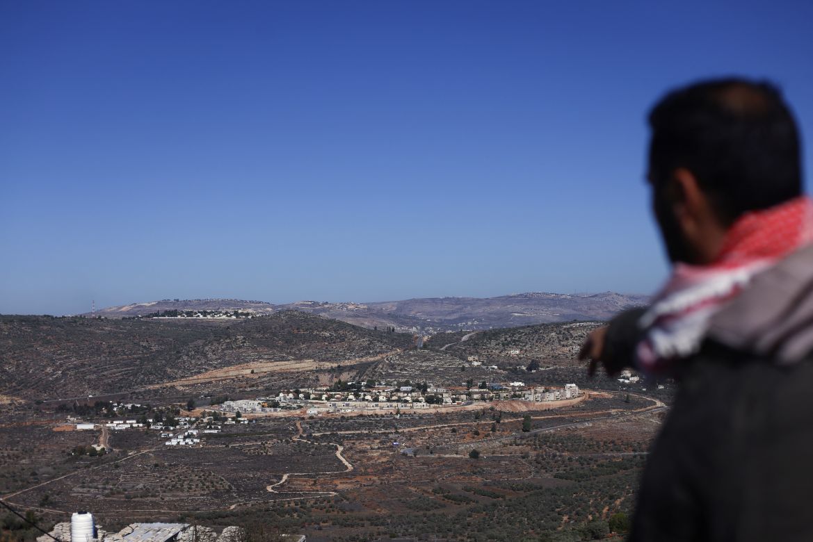 A relative of Palestinian Bilal Saleh points at an Israeli settlement near the village of As-Sawiyah, south of Nablus in the occupied West Bank.