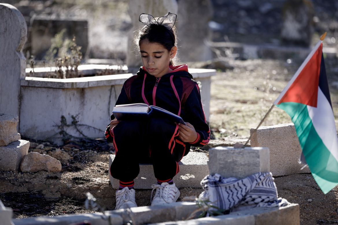 The daughter of Palestinian Bilal Saleh prays near the grave of her late father, at a cemetary in the village of As-Sawiyah, south of Nablus in the occupied West Bank.