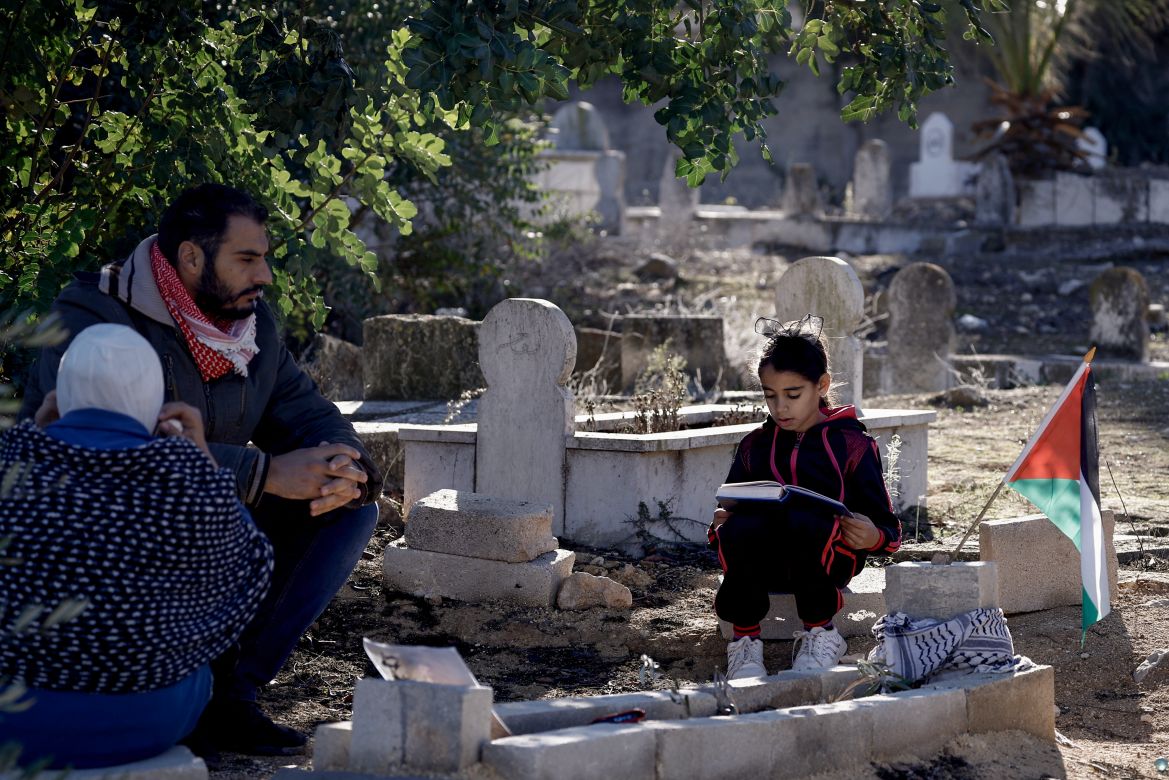Relatives of late Palestinian Bilal Saleh pray at his grave in a cemetary in the village of As-Sawiyah, south of Nablus in the occupied West Bank.