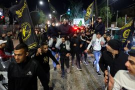 Newly released prisoners are carried by supporters holding Hamas and Islamic Jihad flags, during a welcome ceremony following the release of Palestinians from Israeli jails in Ramallah in the occupied West Bank. [Jaafar Ashtiyeh/AFP]