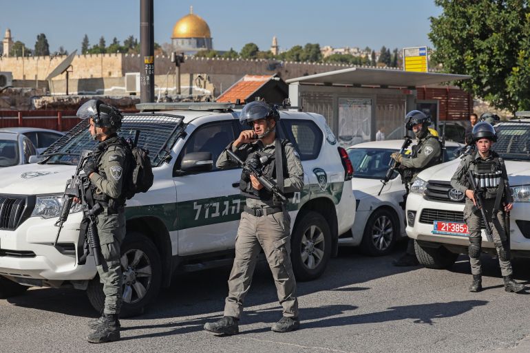 Israeli forces stand guard as Palestinian Muslims perform the Friday noon prayer on the street in the east Jerusalem neighbourhood of Ras al-Amud on December 1