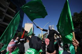 Palestinians raise Hamas flags during a rally in the occupied West Bank city of Hebron on December 1, 2023. [Hazem Bader/AFP]
