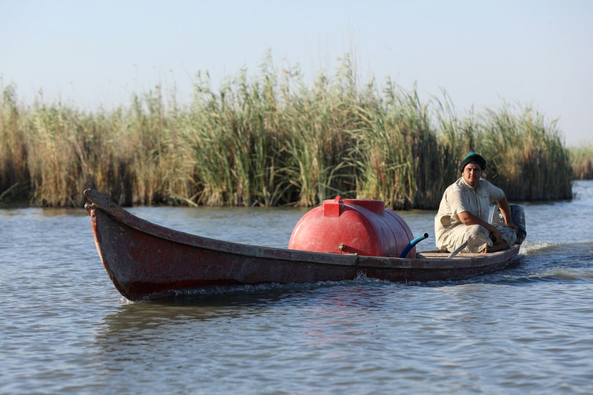 Mohammed Hamid Nour ferries a tank filled with less saline water than the water's edge, to give to his buffaloes in the Chibayish marshland in Iraq's southern Dhi Qar province.