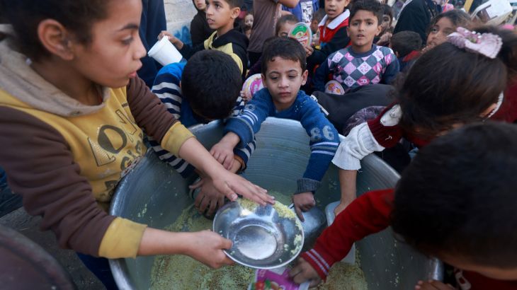 Palestinian children collect food at a donation point