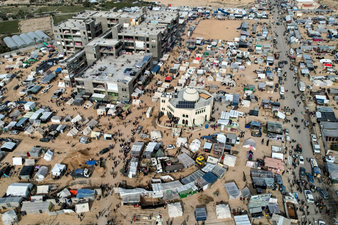 This aerial view taken on December 9, 2023 shows the makeshift tent camps housing Palestinians displaced by intense Israeli bombardment on the Gaza Strip seeking refuge in open areas around the Raed al-Attar Mosque in Rafah in the southern Gaza Strip near the Egyptian border.