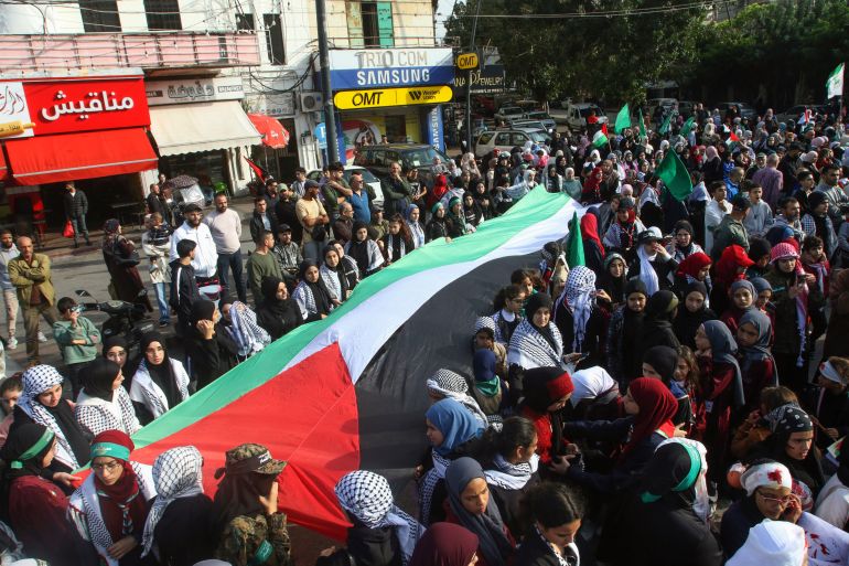 Demonstrators carry a large Palestinian flag during a protest called for by the Islamic movement Hamas in Lebanon's southern city of Sidon.