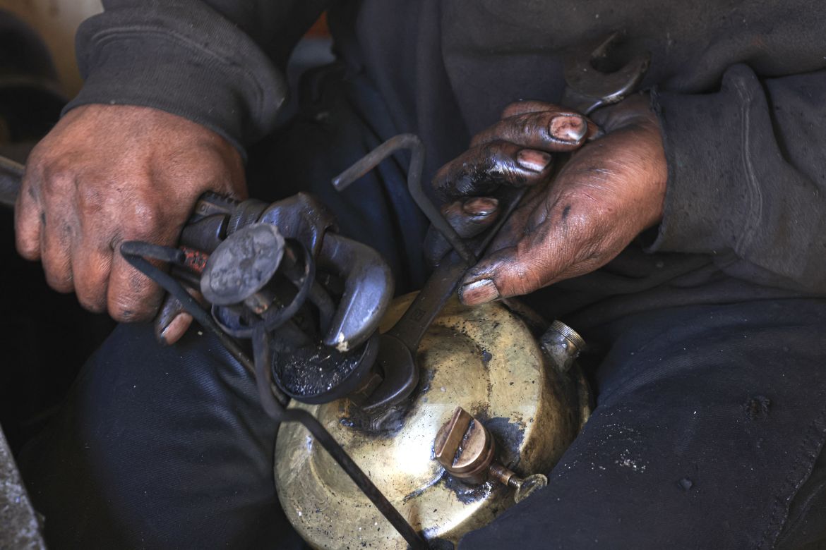 A repairman fixes a kerosene pressure stove in Rafah in the southern Gaza Strip on December 9