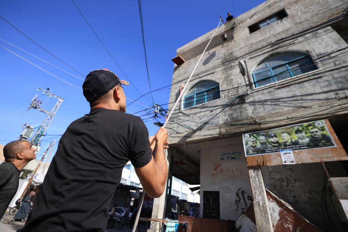 People lift water with a pulley and rope to the roof of a building in Rafah in the southern Gaza Strip on December 9