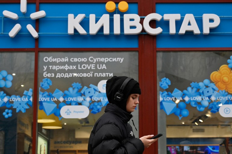 Uma loja Kyivstar com uma mulher passando