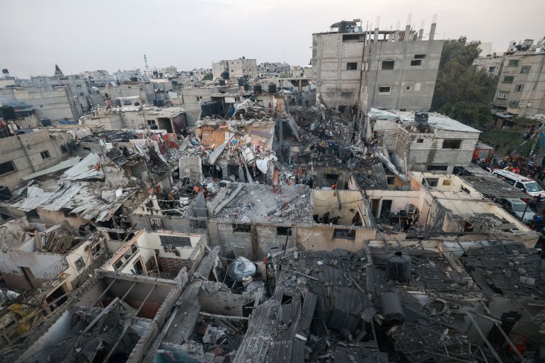Palestinians check the destruction following Israeli bombardment in Rafah, in the southern Gaza Strip on December 12