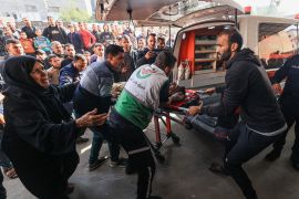 A woman reacts as medics transport a Palestinian man injured in Israeli bombardment, at Nasser hospital in Khan Younis in the southern Gaza Strip on Sunday. [Photo by Mahmud Hams/AFP]