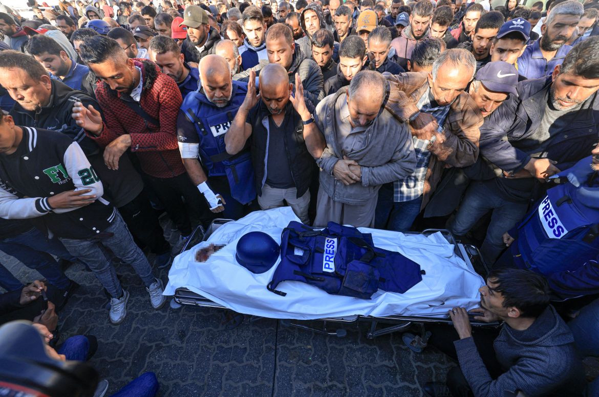 Colleagues and family members pray over the body of Al Jazeera cameraman Samer Abu Daqa, who was killed during Israeli bombardment, during his funeral in Khan Yunis on the southern Gaza Strip.
