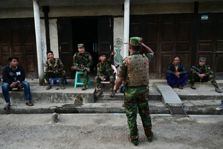 This photo taken on December 12, 2023 shows members of ethnic minority armed group Ta'ang National Liberation Army (TNLA) sitting at a checkpoint amid clashes with Myanmar's military in Namhsan Township in Myanmar's northern Shan State.
