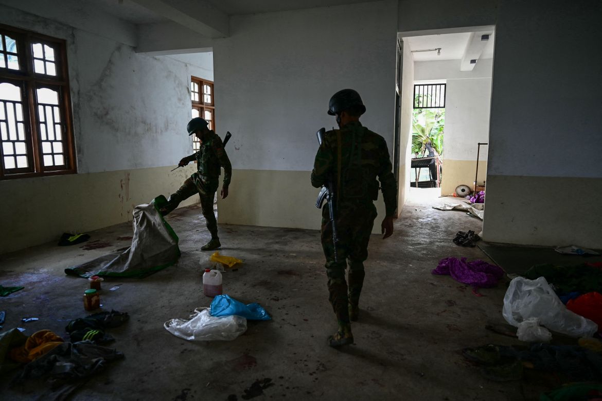 This photo taken on December 12, 2023 shows members of ethnic minority armed group Ta'ang National Liberation Army (TNLA) walking through a building at a hill camp seized from Myanmar's military in Namhsan Township in Myanmar's northern Shan State.