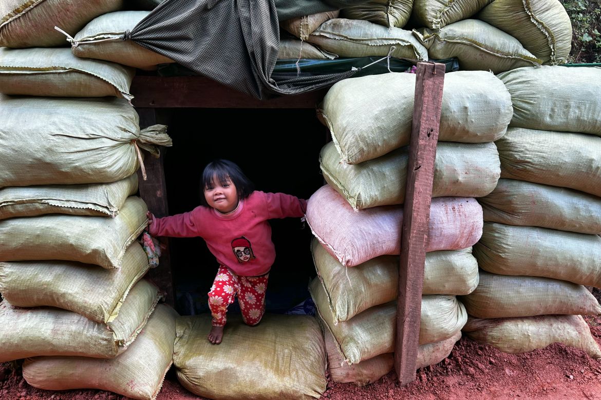This photo taken on December 14, 2023 shows a girl playing in a bomb shelter near her home amid clashes between the ethnic minority armed group Ta'ang National Liberation Army (TNLA) and Myanmar's military in Namhsan Township in Myanmar's northern Shan State.