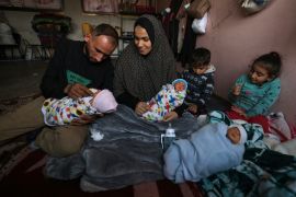 Iman al-Masri holds three of her children