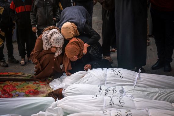 People mourn over the shrouded bodies of loved ones, killed in Rafah during Israeli bombardment on the southern Gaza strip