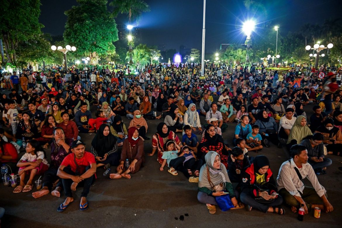 People gather to listen to a music concert to celebrate New Year's Eve at city hall in Surabaya on December 31, 2023.