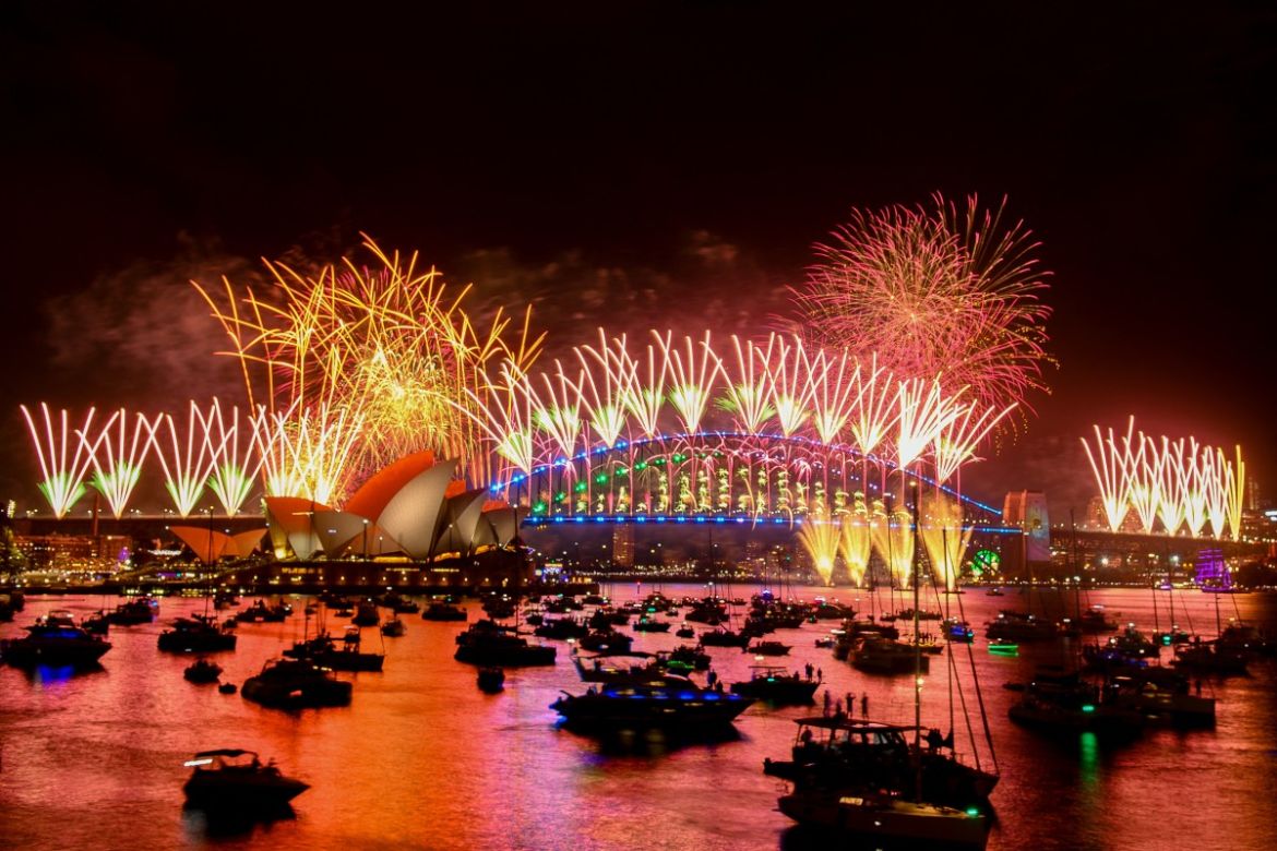 Fireworks explode over the Sydney Harbour Bridge and Sydney Opera House (L) during New Year's Eve celebrations in Sydney on January 1, 2024.