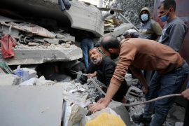 Residents and civil defense teams conduct a search and rescue operation among the rubbles of demolished buildings after Israeli attacks in Deir Al-Balah