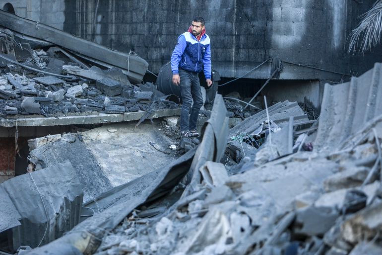 Palestinians search through rubble in the aftermath of a strike in Rafah