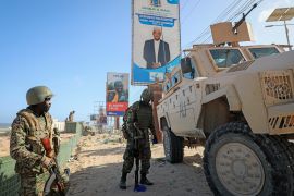 Ugandan peacekeepers with the African Transition Mission in Somalia (ATMIS) stand next to their armored vehicle on a street in Mogadishu, Somalia, May 10, 2022 [Farah Abdi Warsameh/AP Photo]
