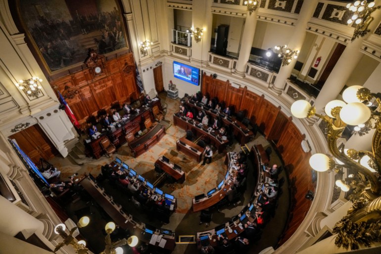 An aerial view looking down on a government chamber where a constitutional council is in session.