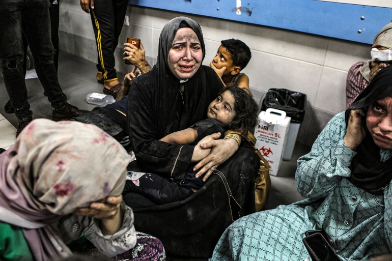 Wounded Palestinians sit in Shifa Hospital in Gaza City, central Gaza Strip, after arriving from al-Ahli Hospital following an explosion there, Tuesday, Oct. 17, 2023.