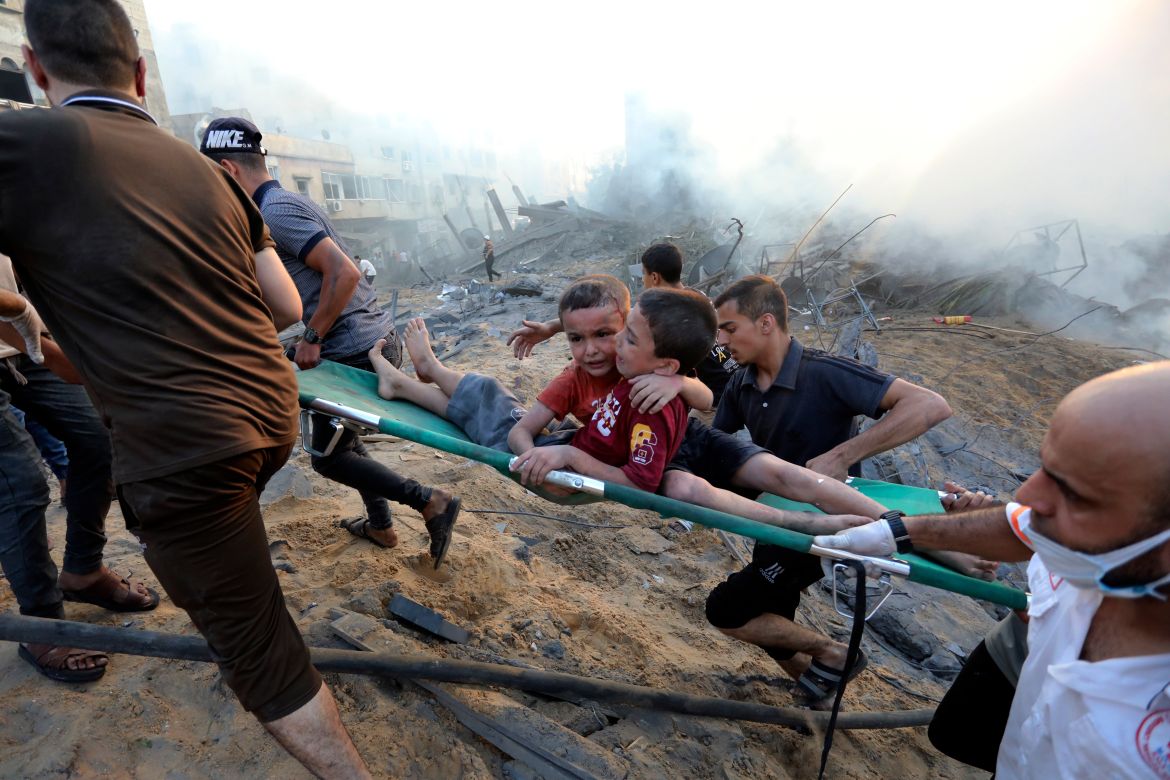 Palestinians evacuate two wounded boys out of the destruction following Israeli airstrikes on Gaza City