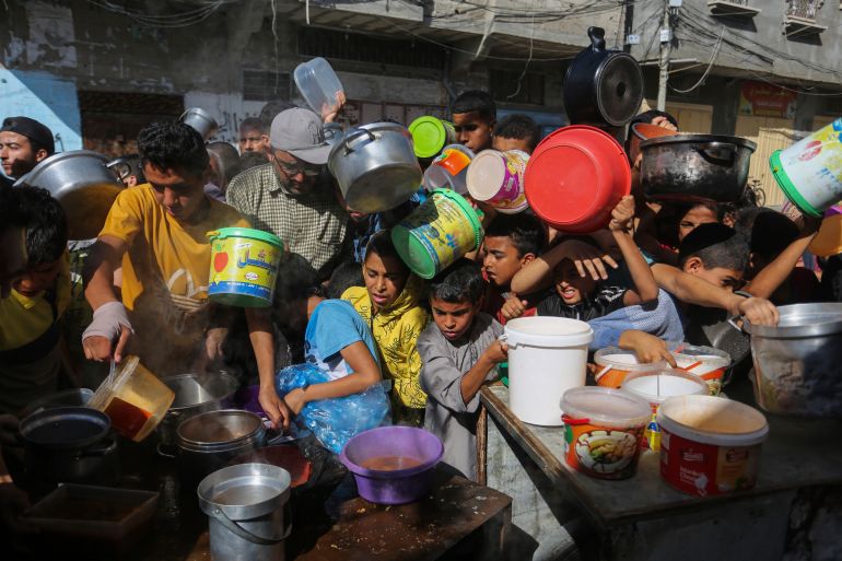 Palestinians crowd together as they wait for food distribution in Rafah