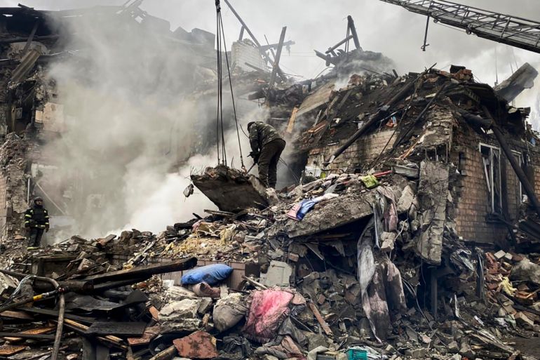 우크라이나 동부에서 러시아의 공격으로 건물이 피해를 입은 현장에서 구조대원들이 구조작업을 하고 있다.  건물은 큰 잔해 더미로 축소되었습니다.