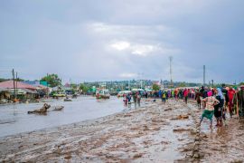 Residents survey the aftermath of flooding in the town of Katesh, Tanzania, on December 3 [AP Photo]
