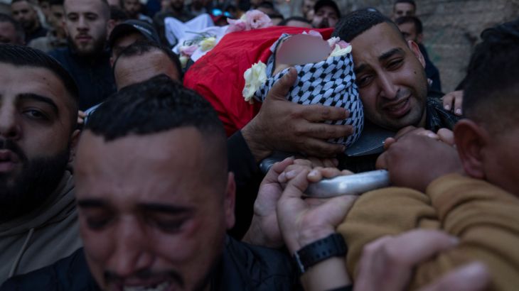 Palestinian mourners carry the body of a deceased person wrapped in cloth