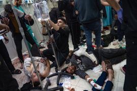 Palestinians wounded in the Israeli strikes on Khan Younis are treated on the floor of the Nasser hospital on Tuesday [Fatima Shbair/AP Photo]