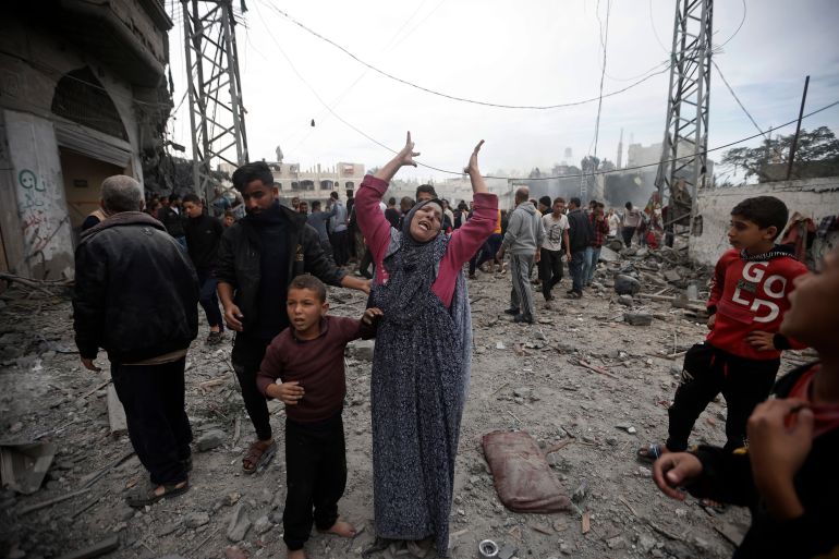 Una donna palestinese fa gesti dopo gli attacchi aerei israeliani nel campo profughi di Khan Younis, nel sud della Striscia di Gaza.