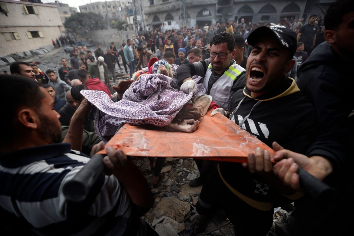 Palestinians carry a dead girl, found under the rubble of a destroyed building following Israeli airstrikes in Khan Younis refugee camp, southern Gaza Strip.