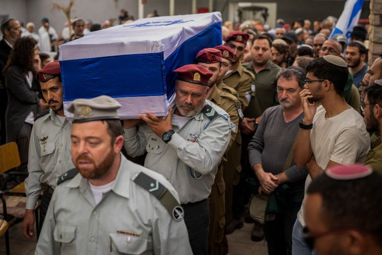 Israeli soldiers carry the flag-draped casket of soldier Staff Sergeant Emanuel Feleke during his funeral at the Kiryat Gat's military cemetery, Israel, Thursday