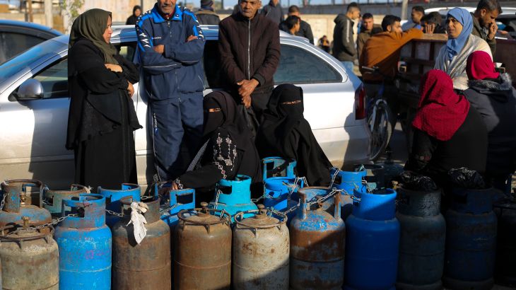 Palestinias line up for cooking gas during the ongoing Israeli bombardment of the Gaza Strip in Rafah on Sunday, Dec. 10