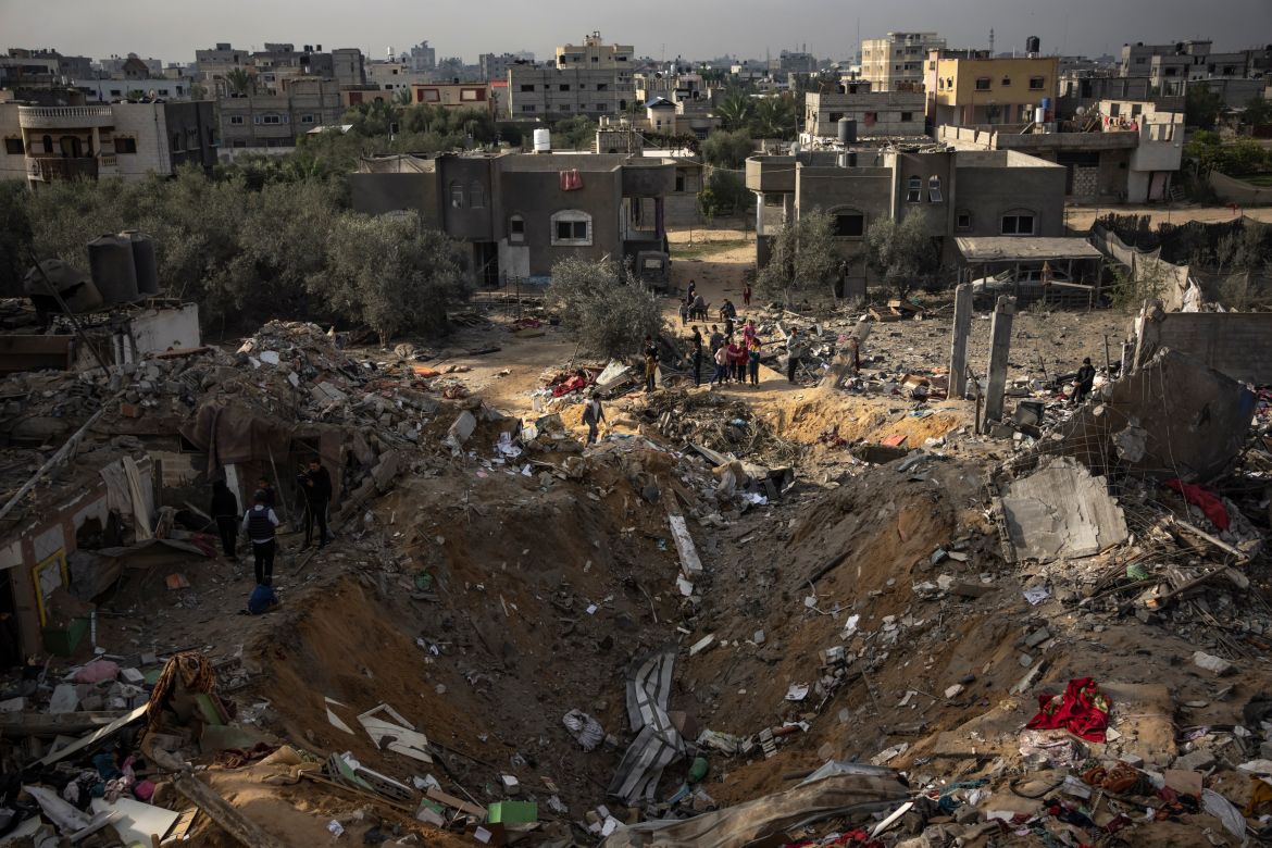 Palestinians inspect a site after it was hit by an Israeli bombardment on Rafah, Gaza Strip, Tuesday, Dec. 12