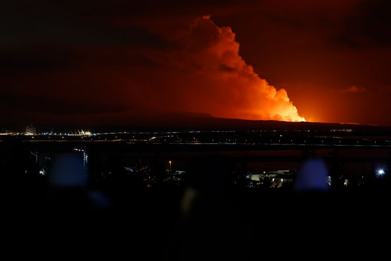 The eruption of a volcano on the Reykjanes peninsula of south-west Iceland eruption seen from Reykjavik. The volcano is a ball of orange, and illuminating the clouds in the darkness