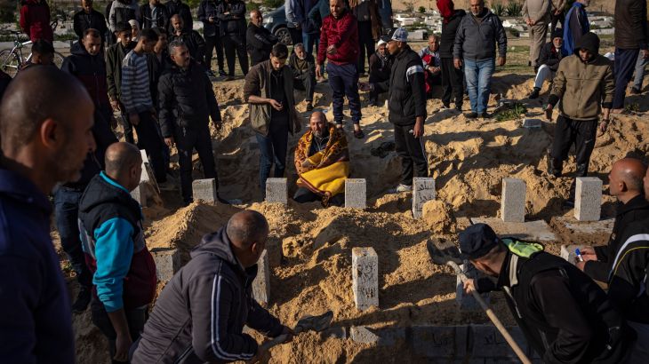 Palestinians bury their relatives killed in the Israeli bombardment of the Gaza Strip, at a cemetery in Rafah, southern Gaza, Tuesday, Dec. 19