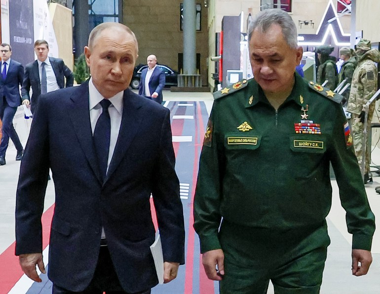 Russian President Vladimir Putin (left) and Russian Defence Minister Sergei Shoigu walking together