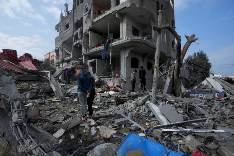 Palestinians inspect the rubble of a building of the Al Nawasrah family destroyed in an Israeli strike in Maghazi refugee camp, central Gaza Strip, Monday, Dec. 25, 2023. (AP Photo/Adel Hana)