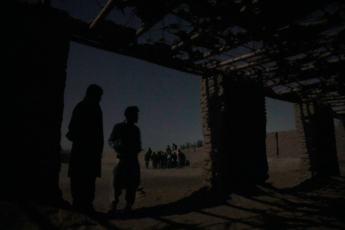 Young Shiite Afghan immigrants wait for midnight in ruins in the desert around the city of Zaranj, Afghanistan, near the the Iran-Afghanistan border wall, to try to cross over the Iranian border wall into Iran, Monday, Dec. 25