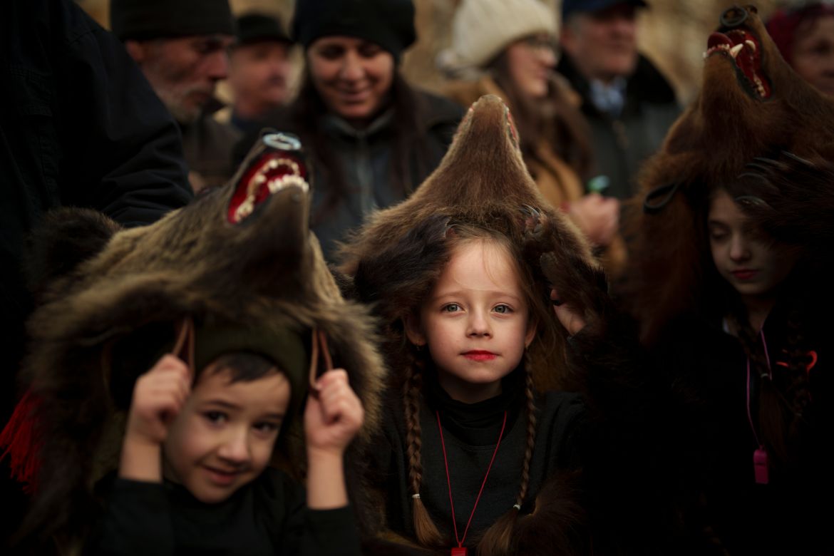 Sofia, 6 years-old, center, a members of a traditional bear pack takes part in a parade before performing in a festival in Moinesti, northern Romania, Wednesday, Dec. 27