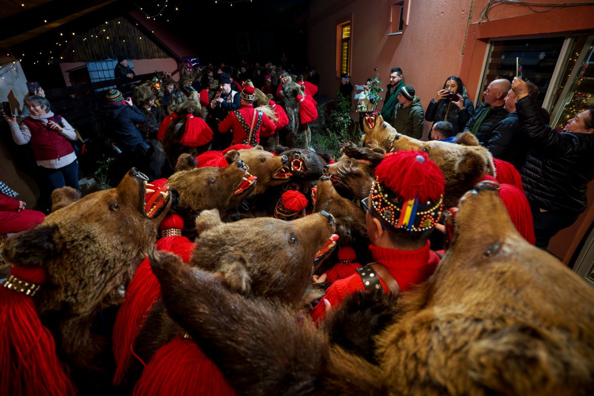 Members of the Sipoteni bear pack perform their ritual dance at a village house in Brusturoasa, northern Romania, Tuesday, Dec. 26