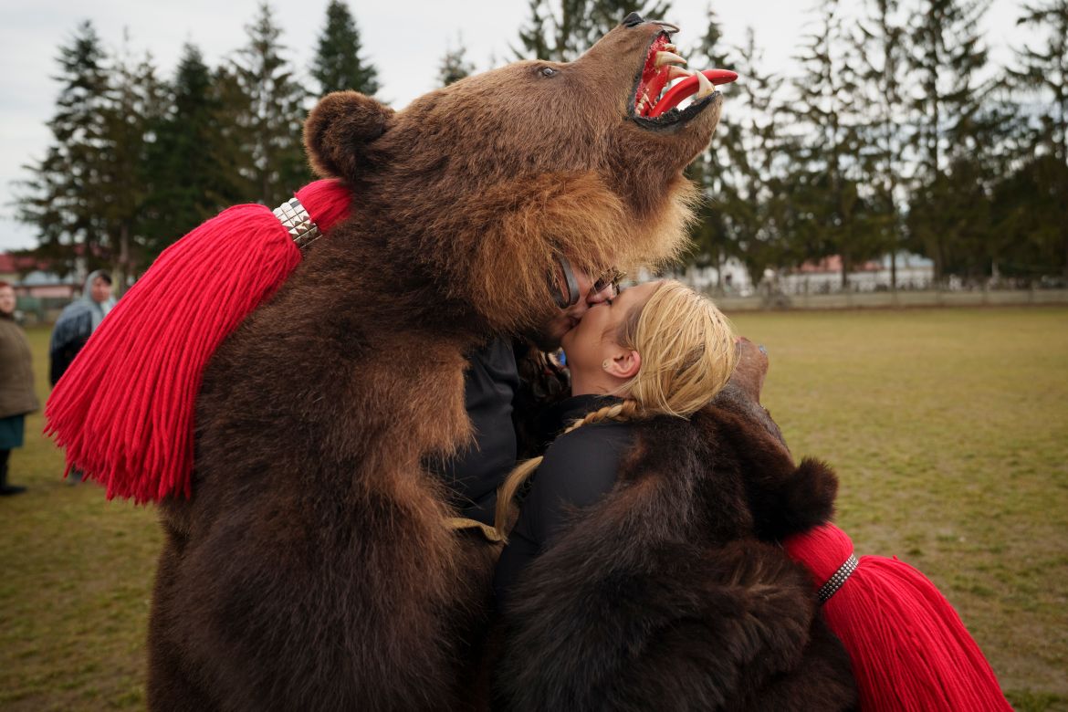 Members of the Sipoteni bear pack kiss after perform a ritual dance in Racova, northern Romania, Tuesday, Dec. 26