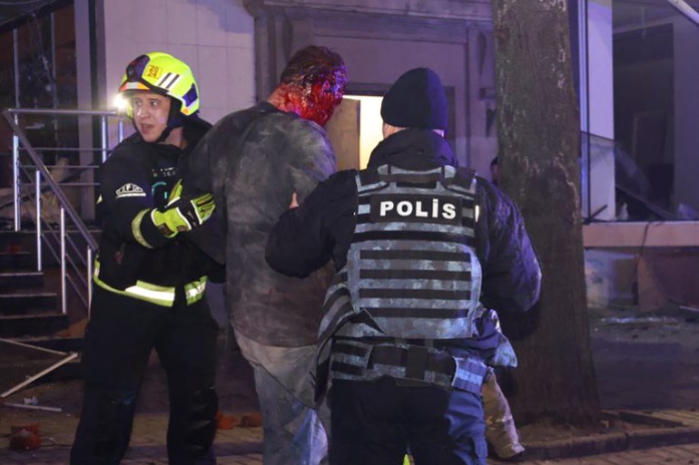 Police and emergency workers help a wounded resident in Kharkiv