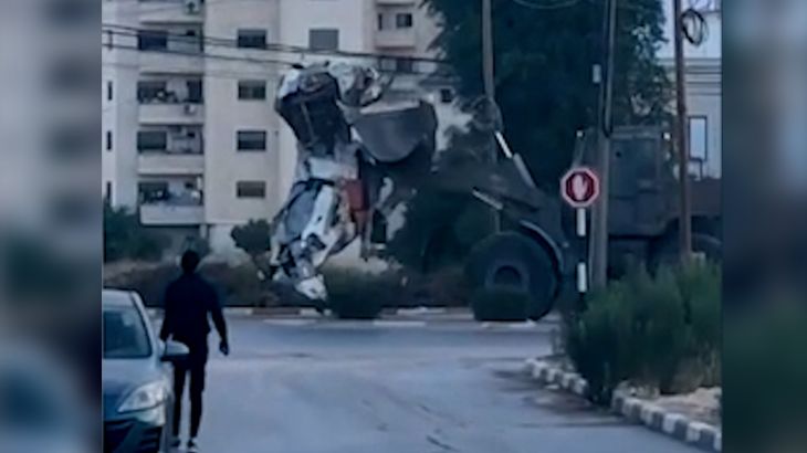 Israeli armoured bulldozer carrying off horse statue in West Bank city of Jenin.